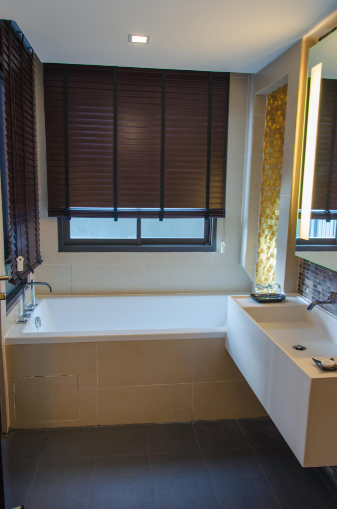 Moisture-resistant faux wood blinds installed in modern Houston bathroom window